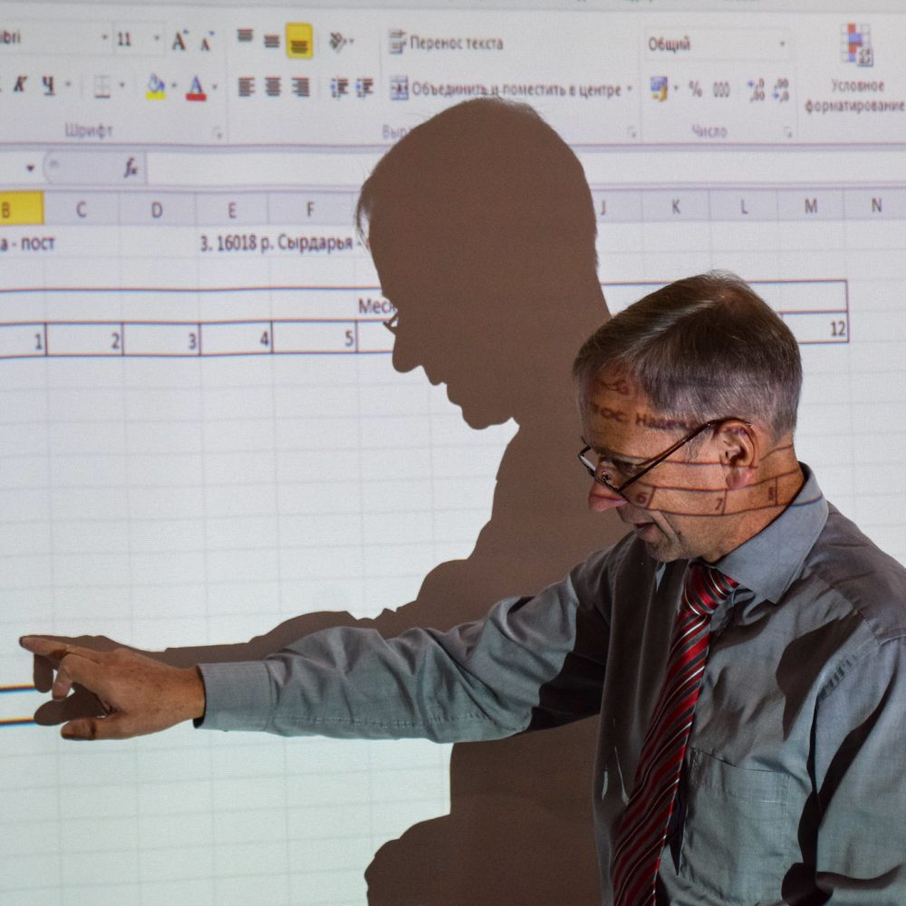 Man pointing at projected data, by Randy McCracken in Uzbekistan